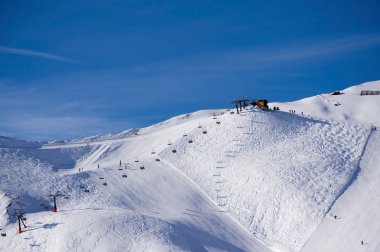 Ski slope with skiing and snowboarding in touristic resort Obertauern in Austrian Alps mountain range in Austria