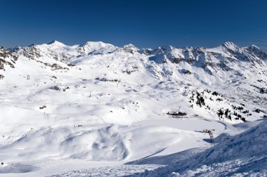 Ski slope with skiing and snowboarding in touristic resort Obertauern in Austrian Alps mountain range in Austria