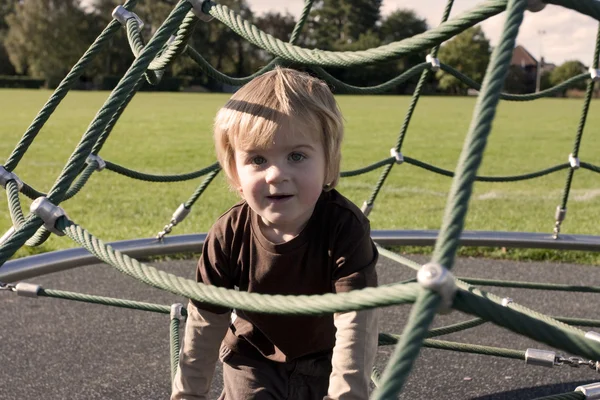 Bonito criança loira brincando fora em um playground — Fotografia de Stock