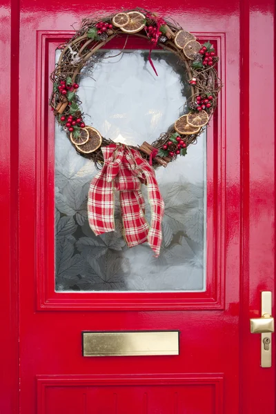 Χριστούγεννα στεφάνι στην κόκκινη πόρτα — Φωτογραφία Αρχείου
