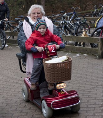 Grandma and grandson on electric mobility scooter clipart