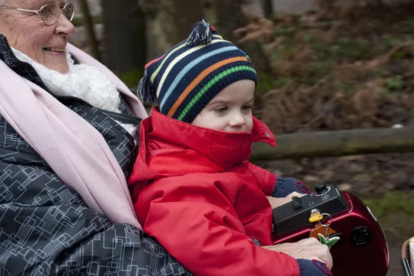 Idosos Senhora Montando Uma Scooter Mobilidade Com Criança — Fotografia de Stock