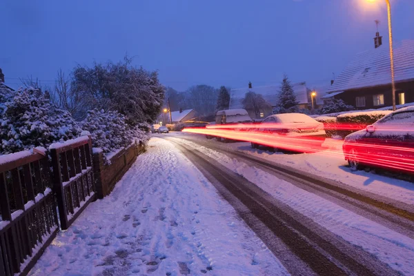 Autolichter strömen an einem verschneiten Abend vorbei — Stockfoto