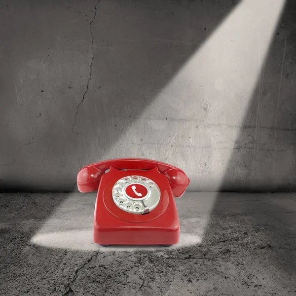 Červený telefon v záři reflektorů — Stock fotografie
