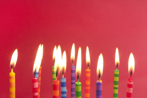 Lots of candles on a red background — Stock Photo, Image