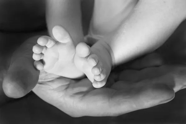 Far cradling barn fötter — Stockfoto