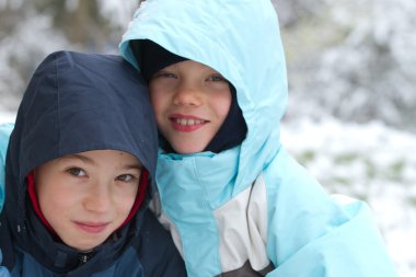 Two smiling children on snow clipart