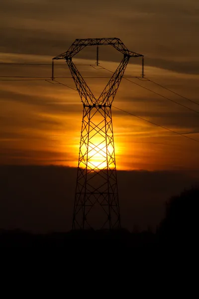 夕阳背后的电力塔 — 图库照片