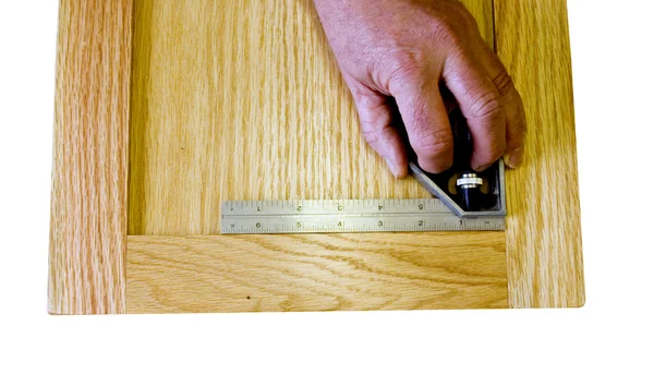 Carpinteiro verificando quadrado de uma porta — Fotografia de Stock