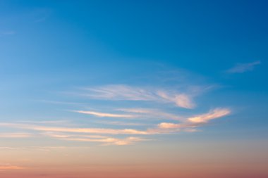 A mostly blue sky in the evening with a few clouds clipart