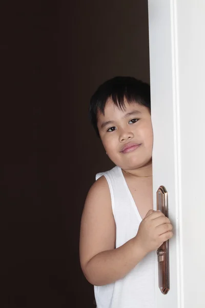 Chico mirando por la puerta — Foto de Stock