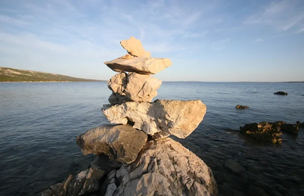 stock image Cross, rocks stacked one one top of another on beach