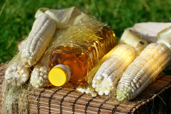 Bottle of yellow oil and corn — Stock Photo, Image