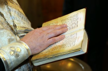 The bible in hands of the priest. Close up clipart