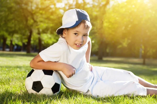 Lindo niño con una pelota en el hermoso parque en la naturaleza ; — Foto de Stock