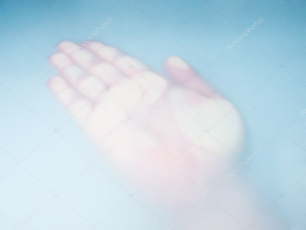 Human hand behind blurred blue glass...
