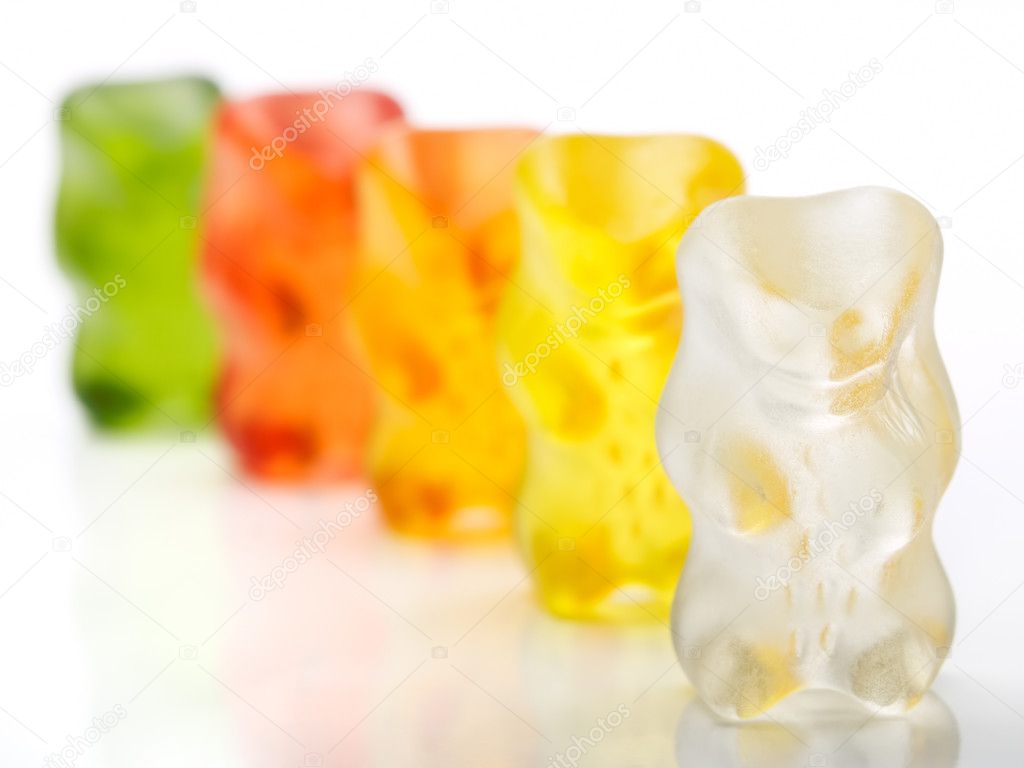 Gummy bears candy in a row on a white background... Shallow DOF.