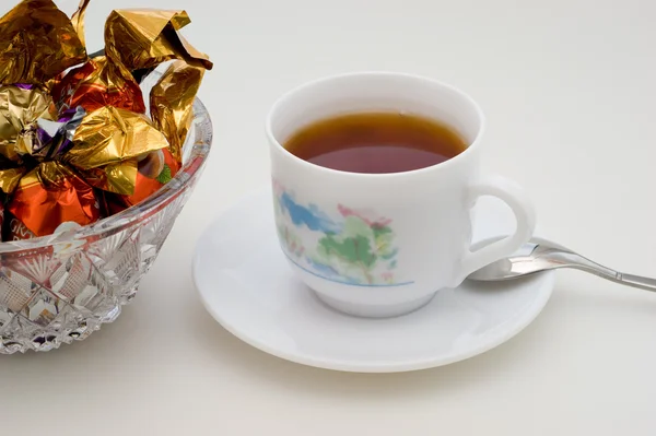 Doces de chocolate e chá preto — Fotografia de Stock