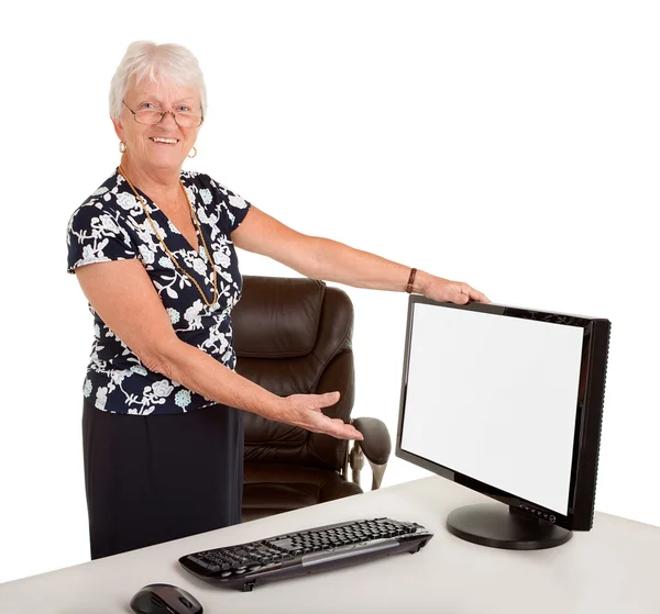 Старшая предпринимательница, указывающая на чистый монитор — стоковое фото