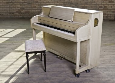 A blond finished upright piano in an old empty factory clipart