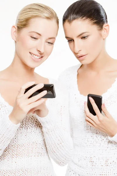 Дві молоді жінки зі смартфонами — стокове фото