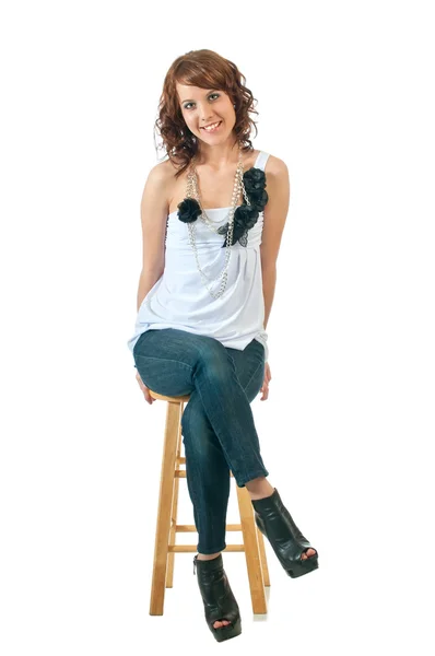 Pretty young woman seated against white background — Stock Photo, Image