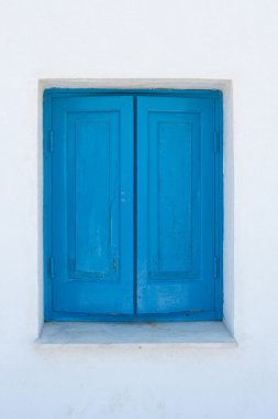 Beyaz bir duvar üzerinde mavi pencere