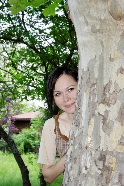 Woman behind the tree — Stock Photo, Image