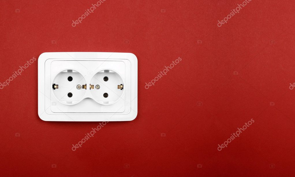 Power outlet on red wall