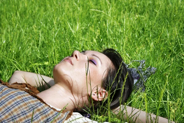Donna sdraiata sull'erba nel parco — Foto Stock