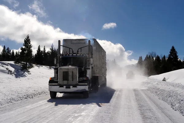 大きなリグと道を運転して 氷のような危険な雪が山の冷たい晴れた日に トラックの後ろに吹くとトレーラー — ストック写真
