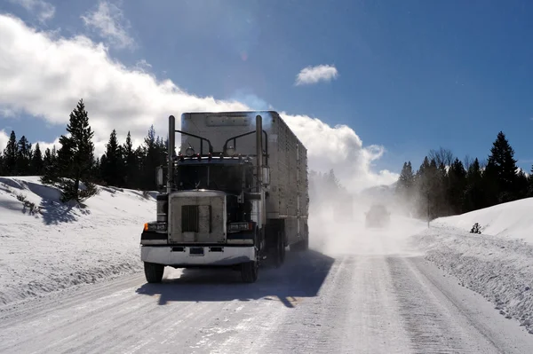 大きなリグと道を運転して 氷のような危険な雪が山の冷たい晴れた日に トラックの後ろに吹くとトレーラー ロイヤリティフリーのストック画像