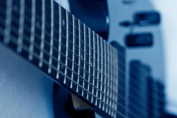 Negro octava cuerda guitarra aislado tonificado azul — Foto de Stock