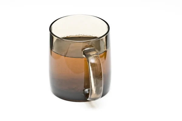 A transparent black cup with tea and tealeafs — Stock Photo, Image