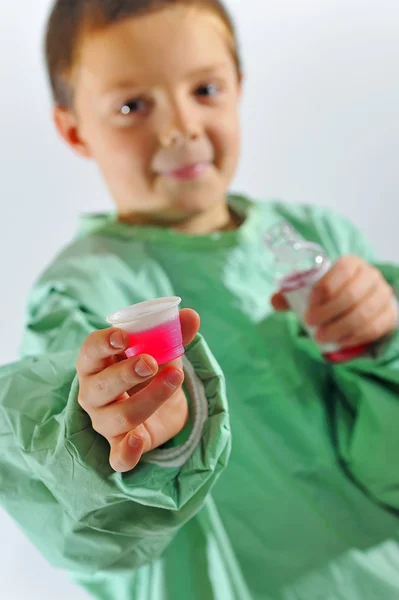 Little doctor boy giving syrup — Stock Photo, Image