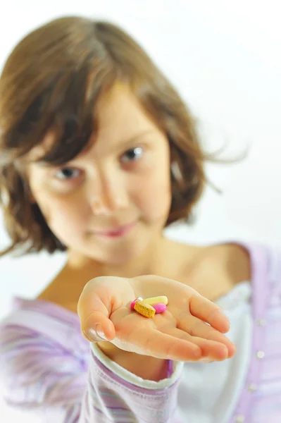 Meisje met pillen in hand — Stockfoto