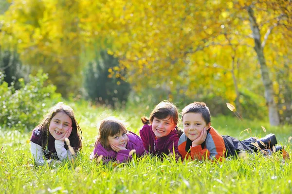 Kleine Jungen und Mädchen legen sich auf Gras — Stockfoto