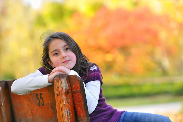 Dívka, kterým se stanoví na lavičce — Stock fotografie