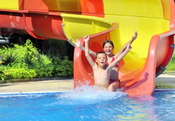 Children sliding down a water slide — Stock Photo, Image