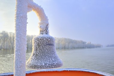 Frozen ship bell in winter time clipart