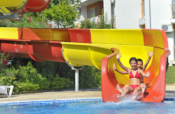 Children sliding down a water slide