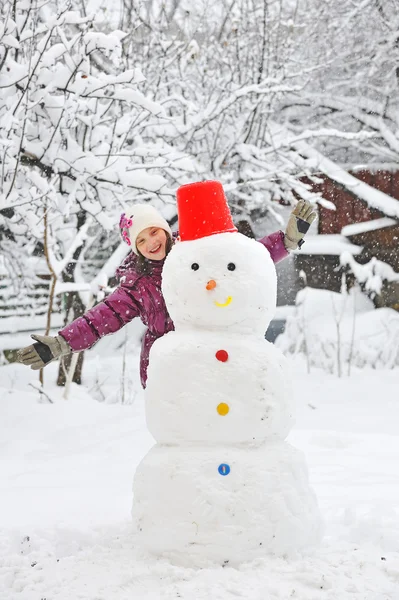 Snowman and young girl — Stock Photo, Image