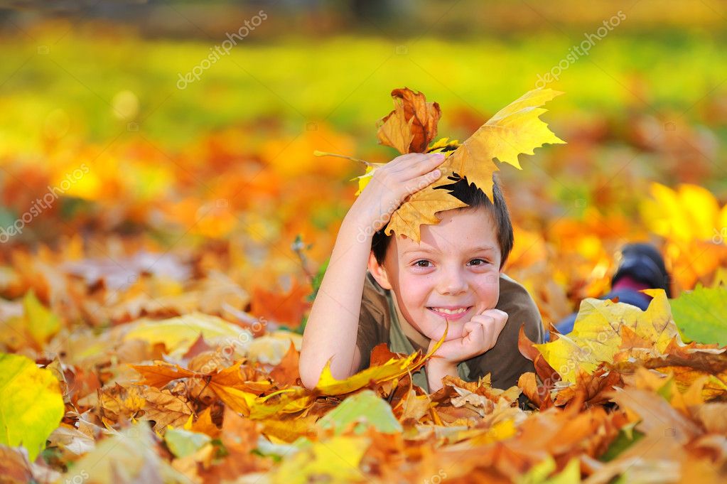 Boy in autumn forest playing with leaves — Stock Photo © jordache #4853868