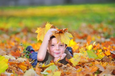 Kid playing with leaves clipart