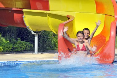 Children sliding down a water slide clipart