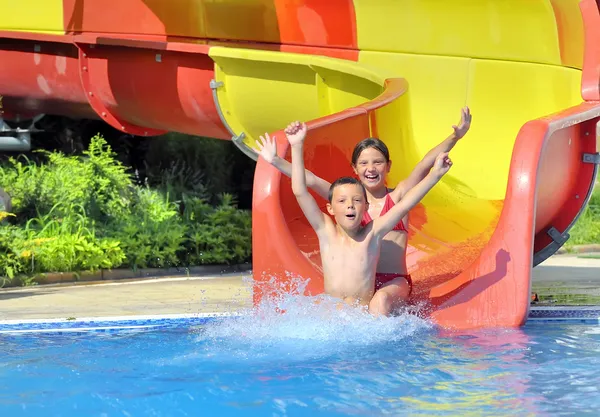 Children sliding down a water slide Stock Image