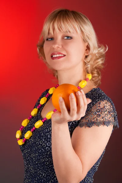 Woman with orange on a red — Stock Photo, Image