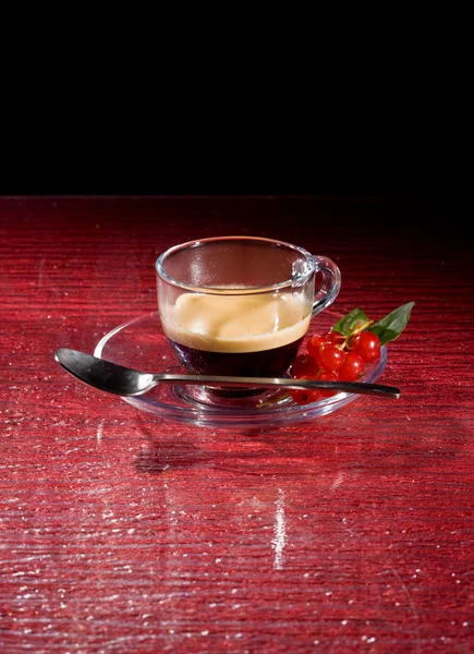 Espressokaffee mit Johannisbeeren auf schwarzem Glastisch — Stockfoto