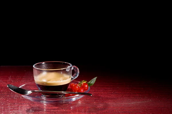 Cofee expresso avec groseilles sur table en verre noir — Photo