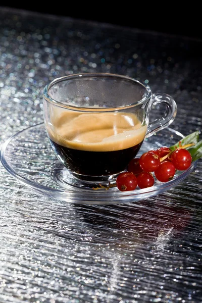 Espresso cofee with currants on black glass table — Stock Photo, Image